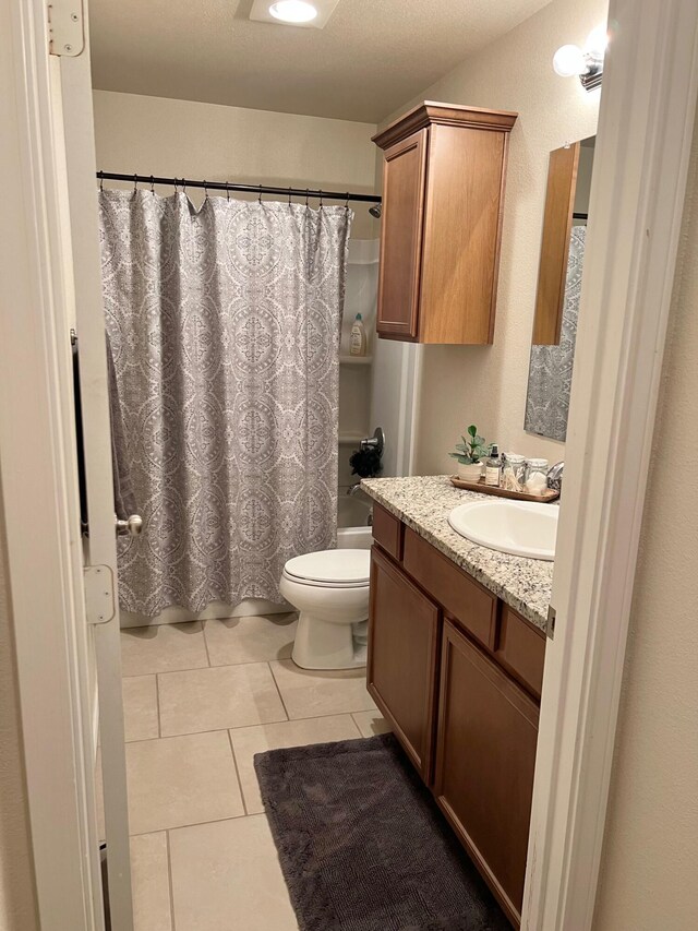 7022 34th Pl, Lubbock, TX 79407 - bathroom with toilet, vanity, tile patterned flooring, and shower / bath combo with shower curtain