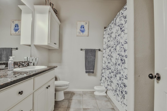 bathroom featuring vanity, tile patterned floors, and toilet