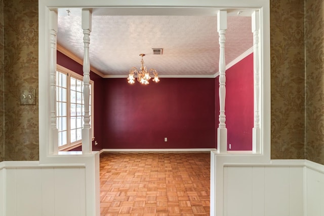 unfurnished dining area featuring a notable chandelier, ornamental molding, a textured ceiling, and light parquet floors