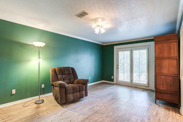 sitting room with crown molding, ceiling fan, a textured ceiling, and light wood-type flooring