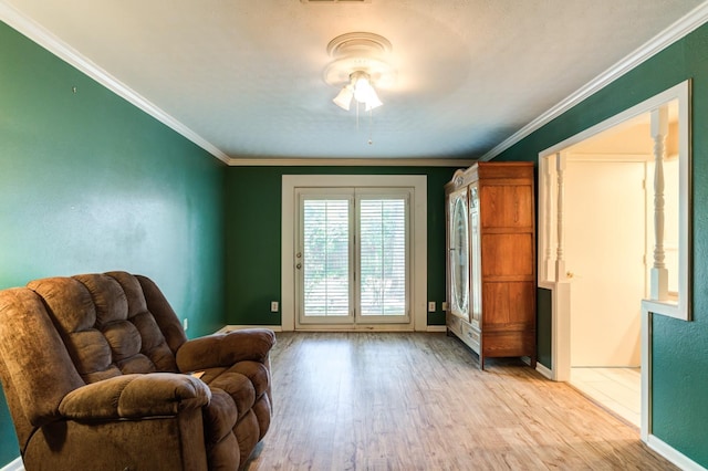 living area with crown molding and light wood-type flooring