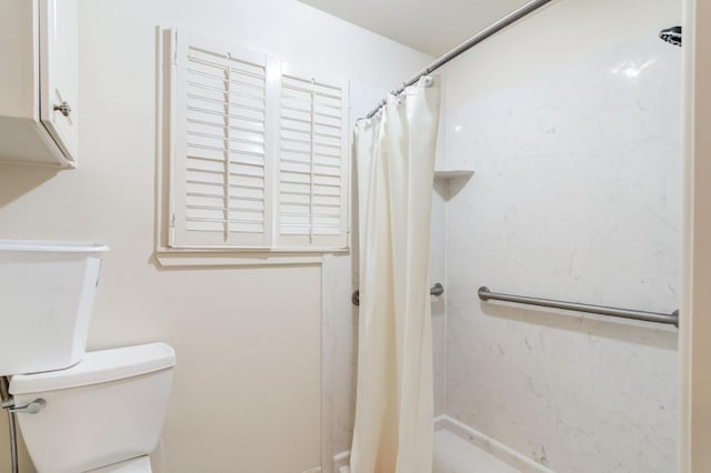 bathroom with toilet and a shower with curtain