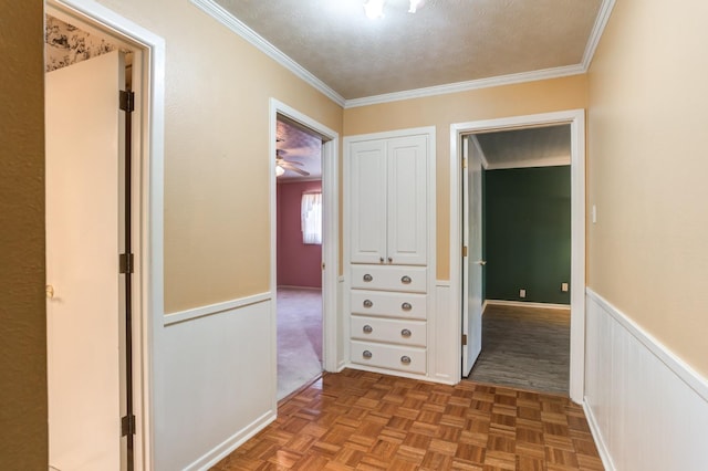 hall featuring parquet flooring, ornamental molding, and a textured ceiling