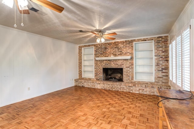 unfurnished living room featuring ceiling fan, ornamental molding, a textured ceiling, built in shelves, and light parquet flooring