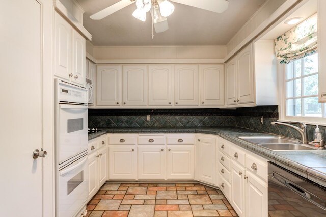 kitchen with white cabinetry, sink, backsplash, and black dishwasher