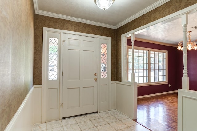 foyer featuring crown molding and a chandelier