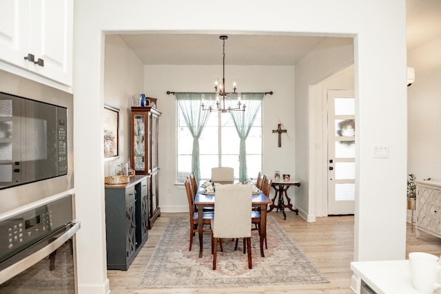 dining room with an inviting chandelier and light wood-type flooring