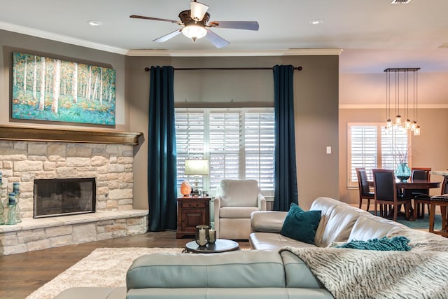 living room featuring hardwood / wood-style floors, a fireplace, ornamental molding, and ceiling fan