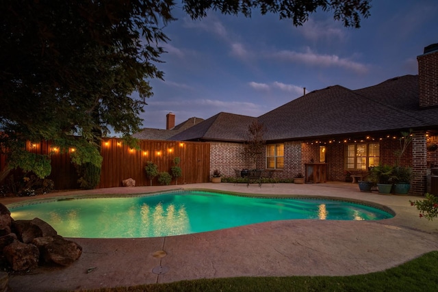 pool at dusk featuring a patio area