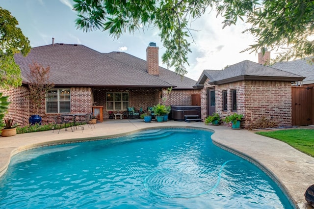 view of swimming pool featuring a patio area and a hot tub