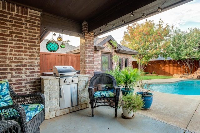 view of patio featuring an outdoor kitchen, grilling area, and a fenced in pool