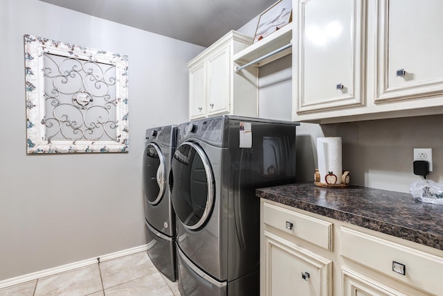 clothes washing area featuring independent washer and dryer, light tile patterned floors, and cabinets