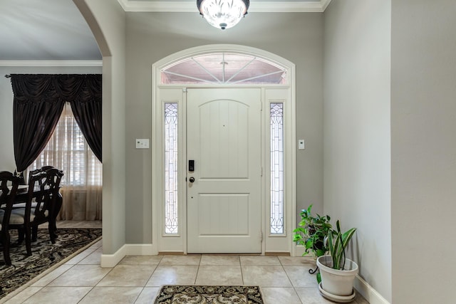 foyer with ornamental molding and light tile patterned floors