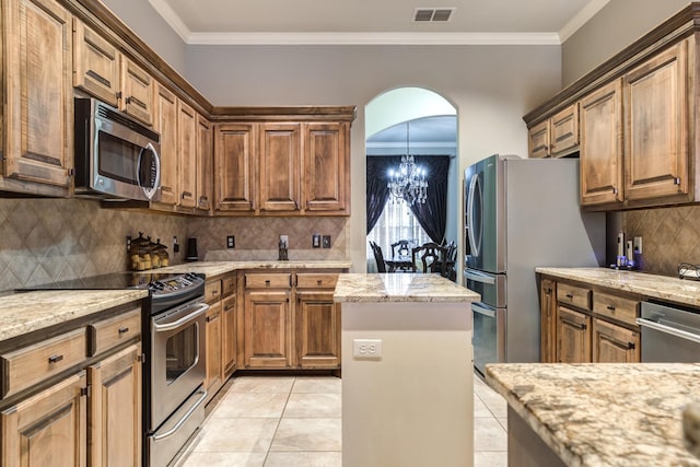 kitchen with light stone counters, stainless steel appliances, and a chandelier