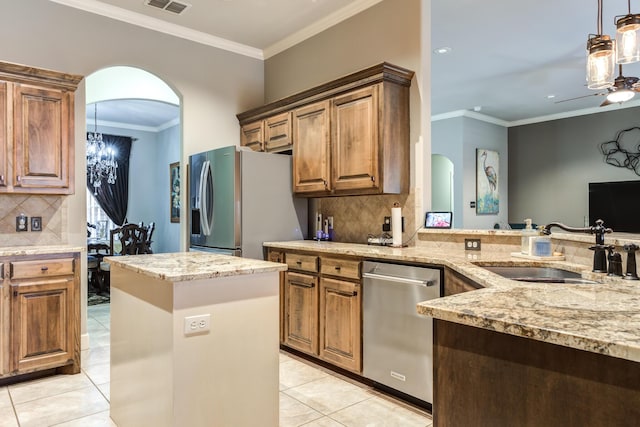 kitchen featuring sink, light tile patterned floors, stainless steel appliances, ornamental molding, and ceiling fan with notable chandelier