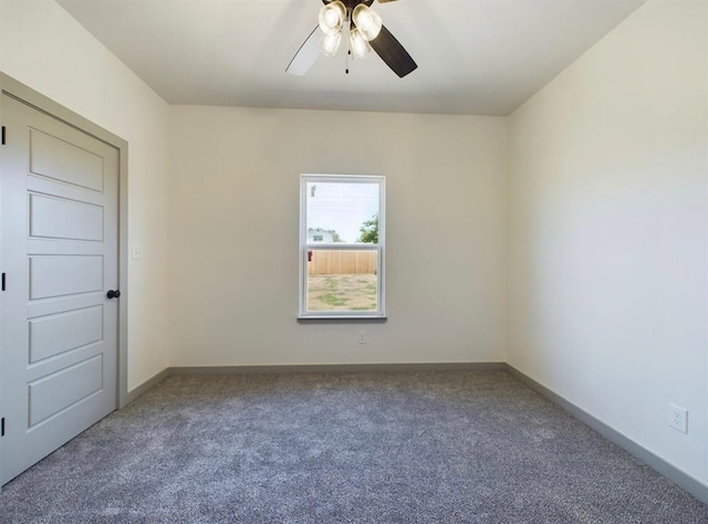 carpeted spare room featuring ceiling fan