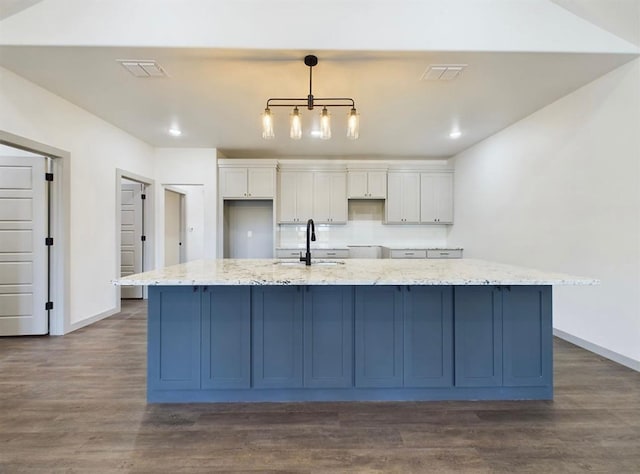 kitchen featuring white cabinetry, a spacious island, sink, and pendant lighting