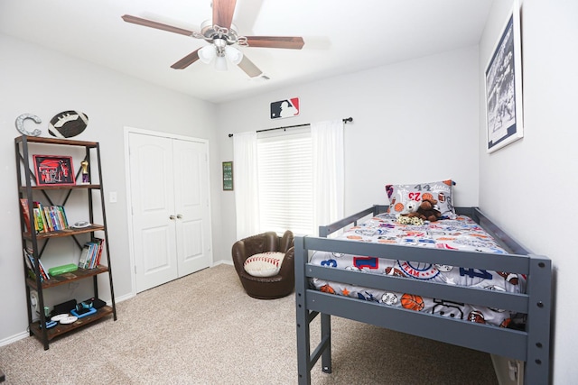 carpeted bedroom featuring ceiling fan and a closet