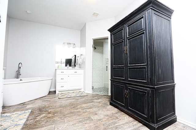 bathroom with vanity, hardwood / wood-style floors, and separate shower and tub