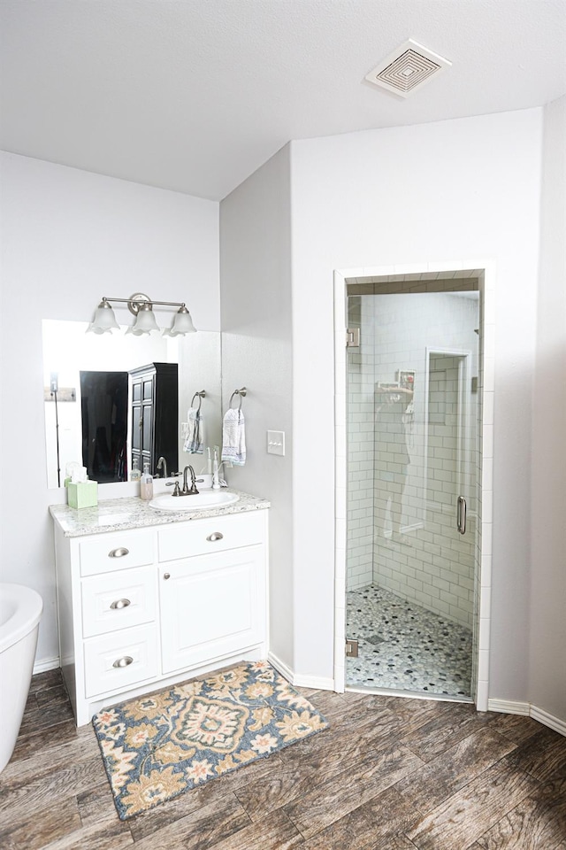 bathroom featuring vanity, hardwood / wood-style floors, and separate shower and tub