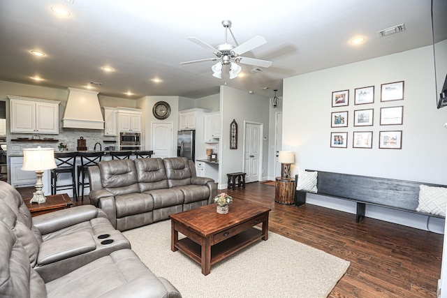 living room with ceiling fan, sink, and dark hardwood / wood-style flooring