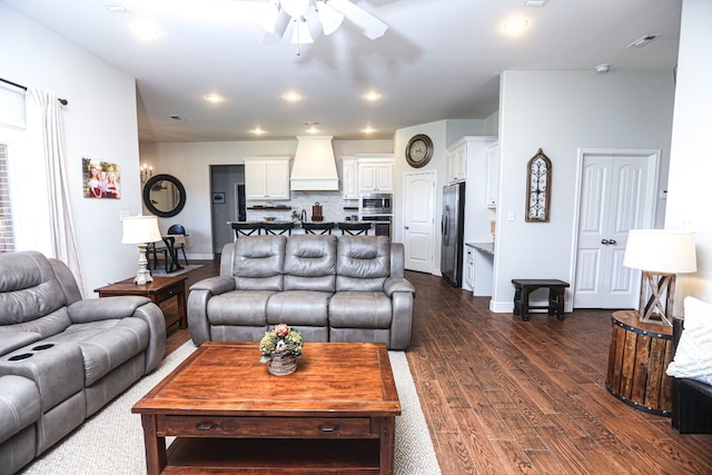 living room featuring dark wood-type flooring and ceiling fan