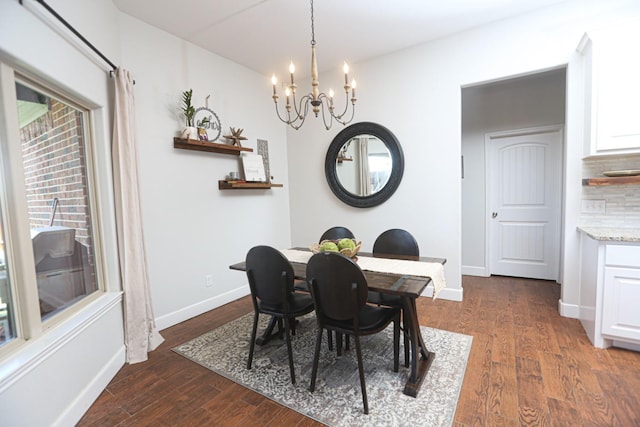 dining space featuring dark wood-type flooring and an inviting chandelier