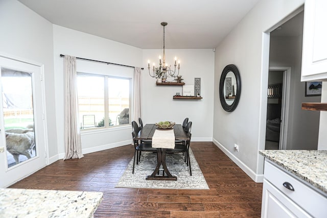 dining area featuring dark hardwood / wood-style flooring and an inviting chandelier