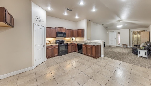 kitchen with light stone countertops, sink, light carpet, and black appliances