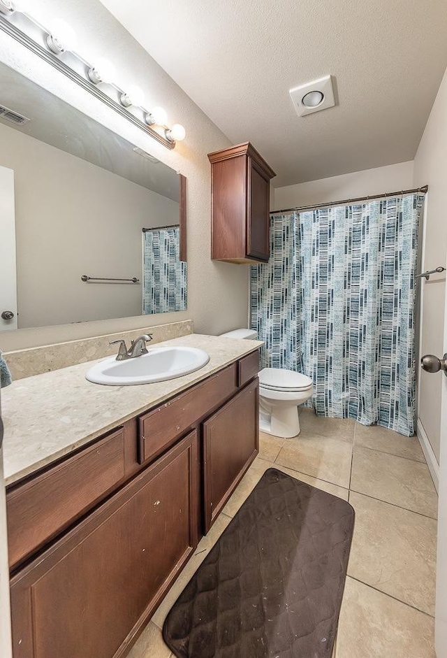 bathroom featuring vanity, tile patterned floors, a textured ceiling, and toilet