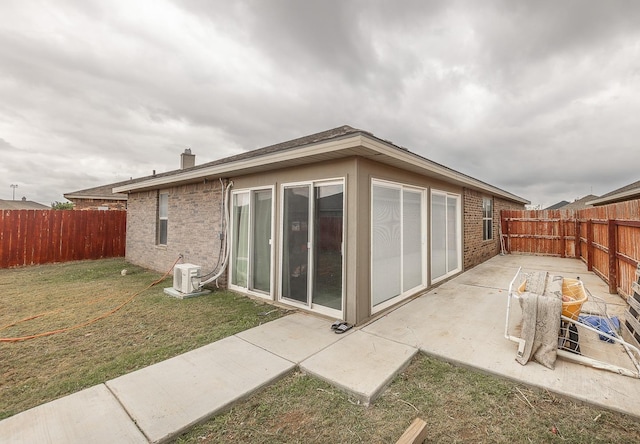 back of house featuring a lawn and a patio