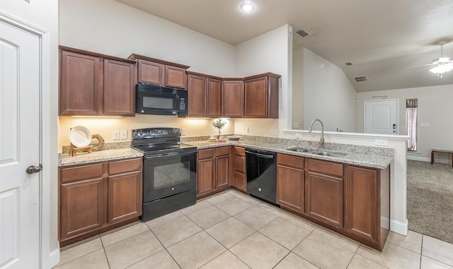 kitchen with black appliances, sink, kitchen peninsula, light stone countertops, and light carpet