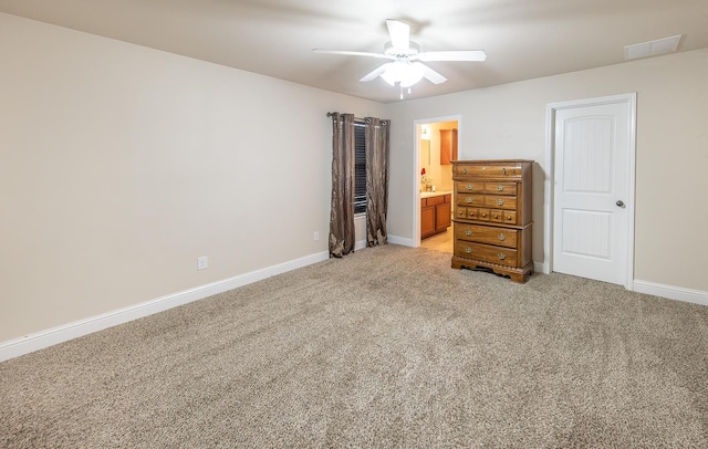 unfurnished bedroom featuring connected bathroom, light colored carpet, and ceiling fan