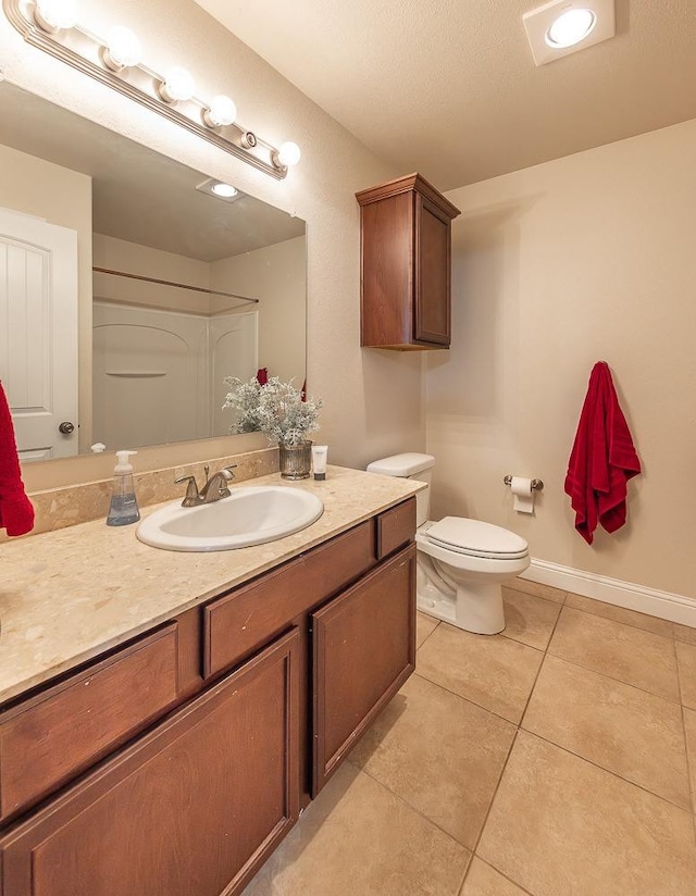 bathroom with tile patterned flooring, vanity, and toilet