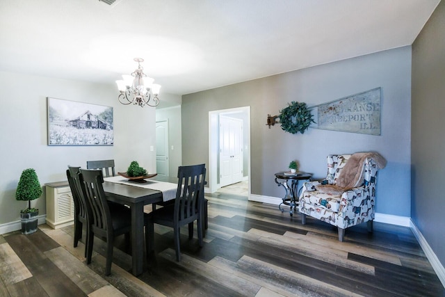 dining room with an inviting chandelier, baseboards, and wood finished floors