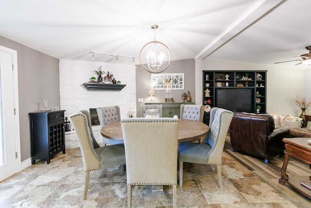 dining space featuring lofted ceiling, rail lighting, and ceiling fan with notable chandelier