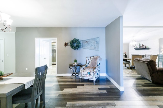 dining space featuring baseboards, a notable chandelier, and wood finished floors