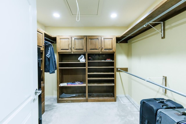 walk in closet featuring light colored carpet and attic access