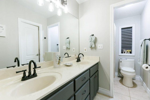 bathroom featuring tile patterned floors, double vanity, toilet, and a sink