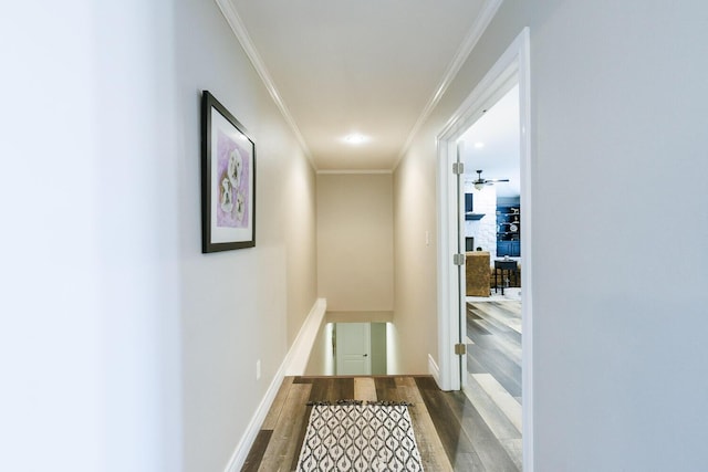 hallway with baseboards, an upstairs landing, dark wood-type flooring, and crown molding