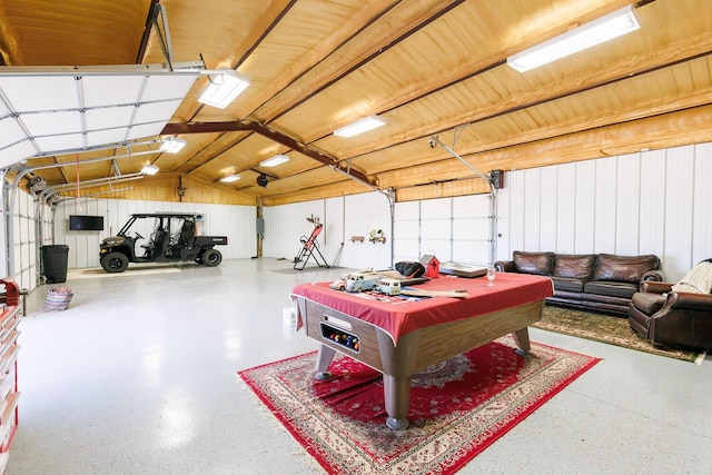 rec room with lofted ceiling, speckled floor, and a garage