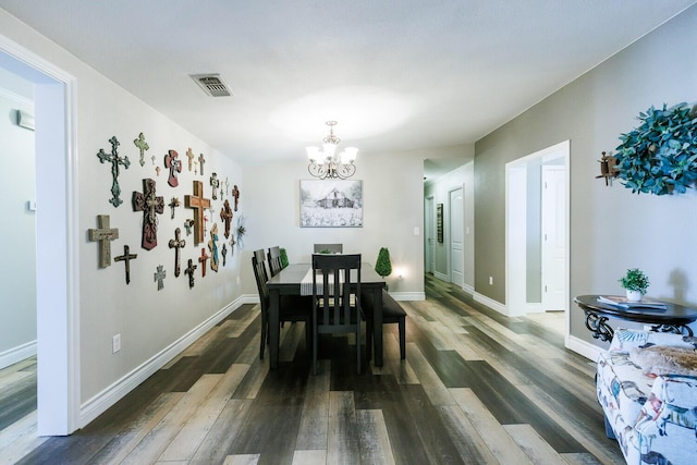 dining space with visible vents, baseboards, an inviting chandelier, and wood finished floors