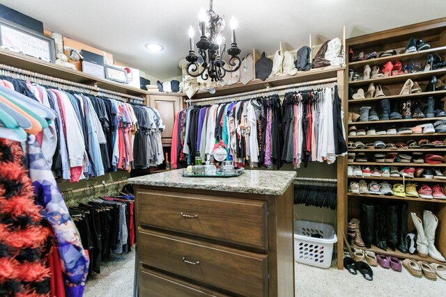 spacious closet with an inviting chandelier