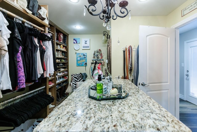 spacious closet featuring a notable chandelier and wood finished floors