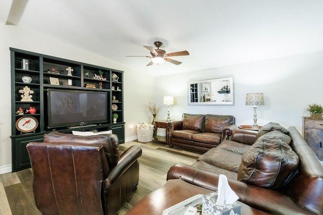 living area with baseboards, wood finished floors, and a ceiling fan