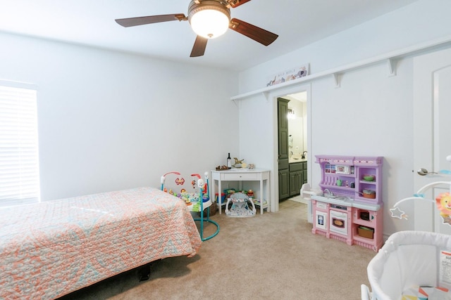 bedroom featuring connected bathroom, light colored carpet, and ceiling fan