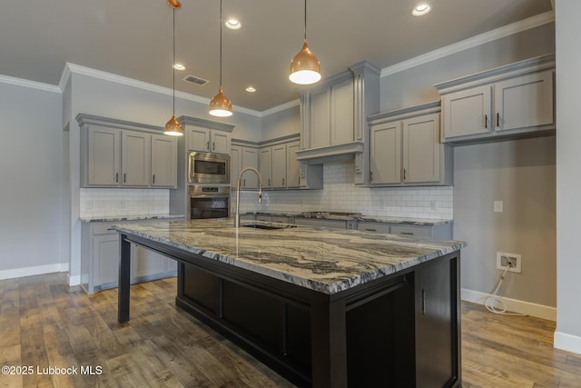 4020 125th St, Lubbock, TX 79423 - kitchen featuring gray cabinets, stainless steel appliances, light stone counters, tasteful backsplash, and dark wood finished floors