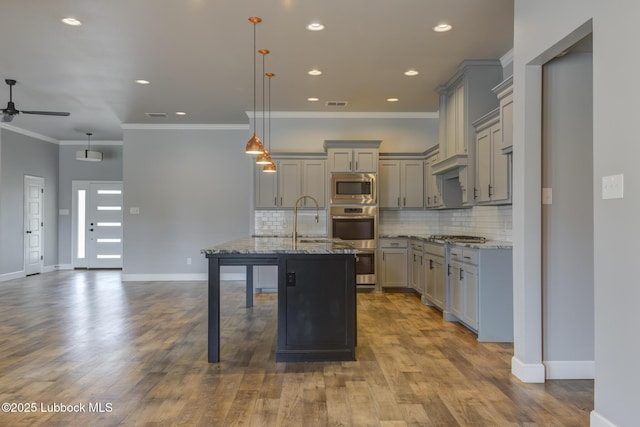 4020 125th St, Lubbock, TX 79423 - kitchen with gray cabinetry, appliances with stainless steel finishes, ceiling fan, light stone counters, and tasteful backsplash