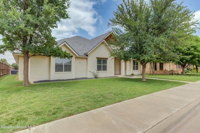 4020 125th St, Lubbock, TX 79423 - view of front of house with brick siding, a front yard, and roof with shingles