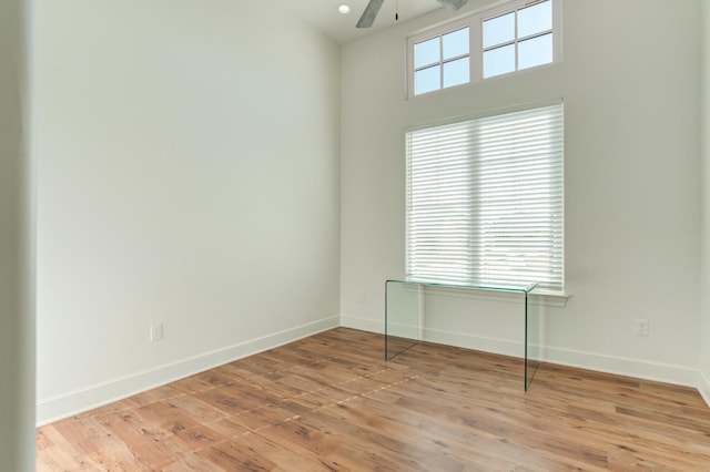 spare room with plenty of natural light, light hardwood / wood-style floors, and ceiling fan